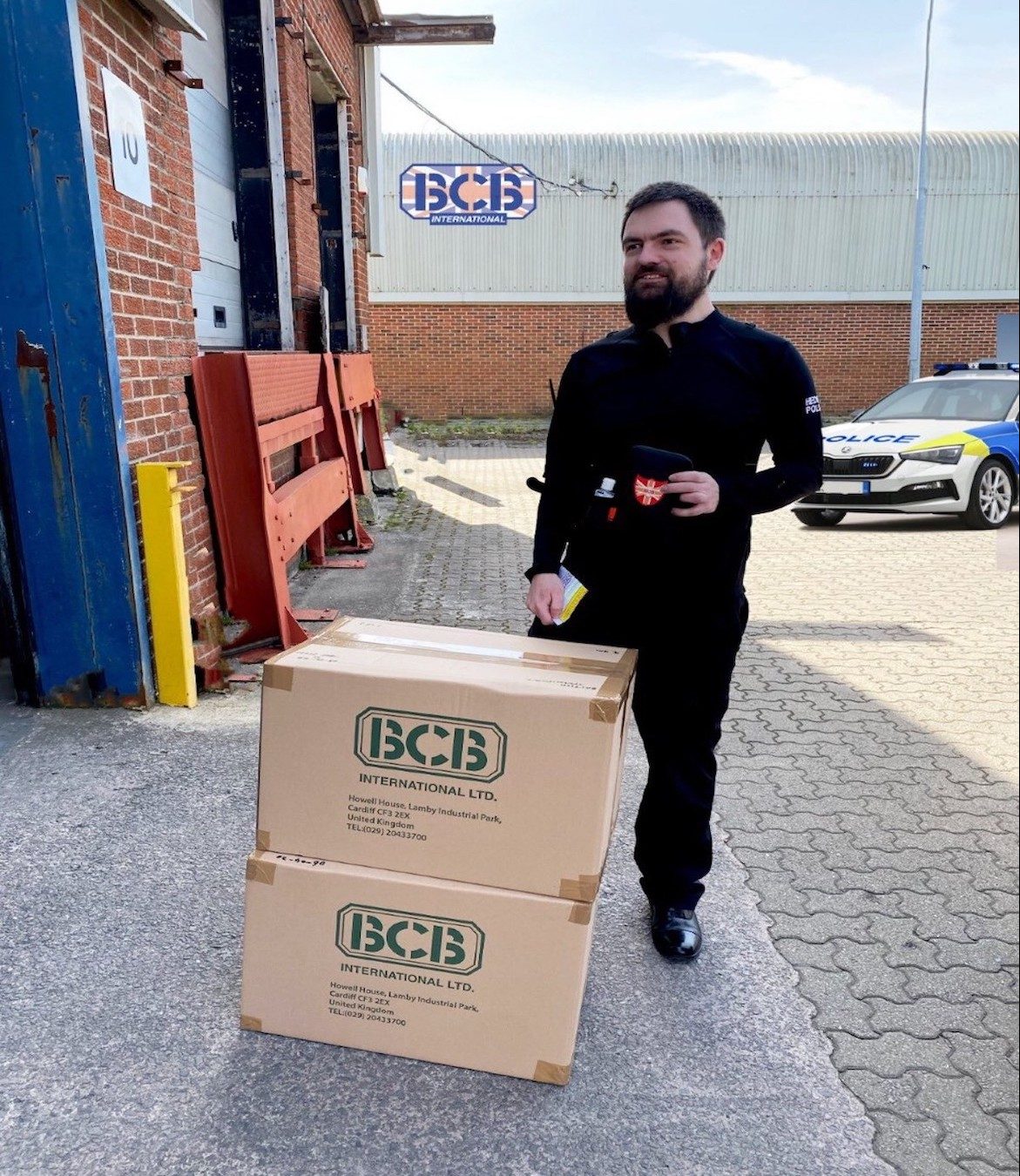 Welsh police officer collecting sanitisers from BCB International at its Llanelli factory